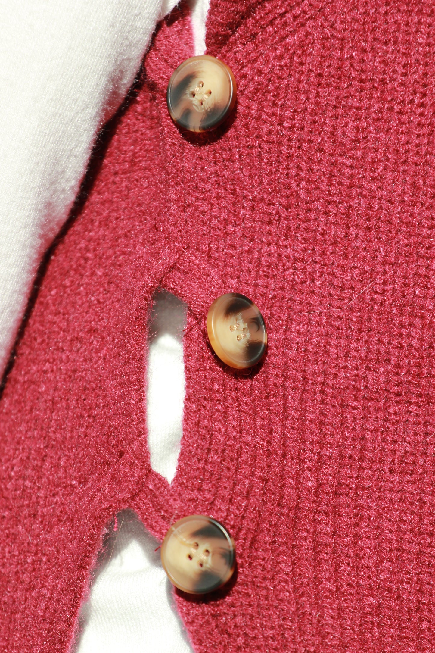 Detailfoto van de lus om de bruine knoop van de bordeauxrode spencer Anna